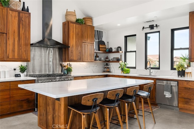 kitchen featuring a kitchen bar, a sink, open shelves, wall chimney range hood, and stainless steel dishwasher