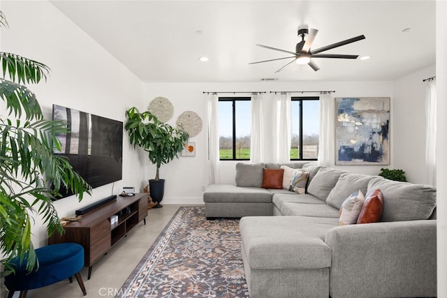 living room featuring baseboards, concrete floors, ceiling fan, and recessed lighting