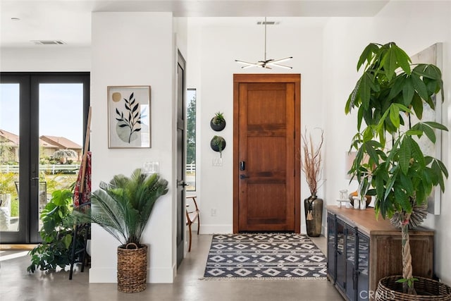 foyer with baseboards, visible vents, french doors, and finished concrete floors