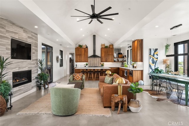living area featuring lofted ceiling, a ceiling fan, a premium fireplace, and finished concrete floors