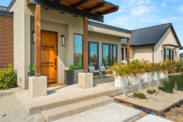 exterior space featuring stucco siding, a standing seam roof, and metal roof