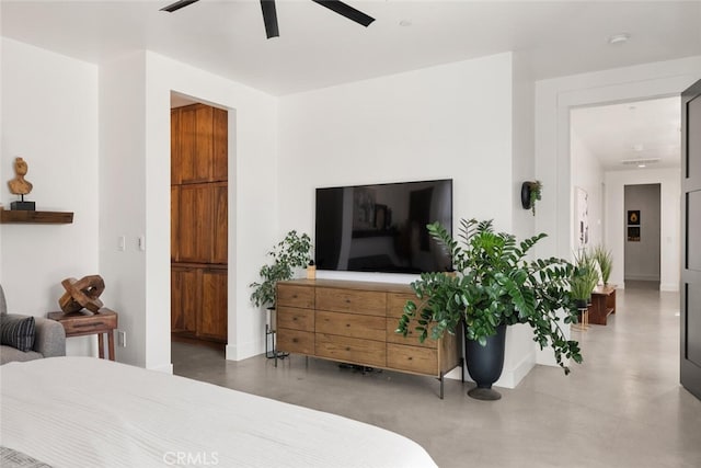 bedroom with baseboards, concrete flooring, and a ceiling fan