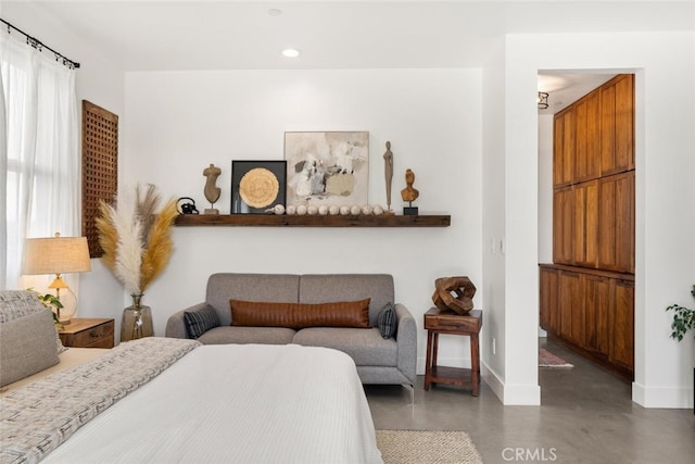 bedroom featuring baseboards, recessed lighting, and finished concrete floors