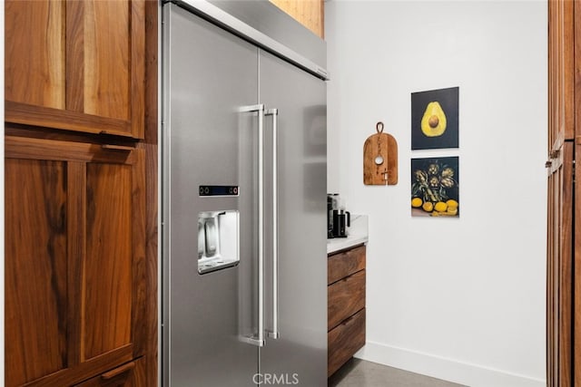 kitchen featuring brown cabinets, light countertops, and high end refrigerator