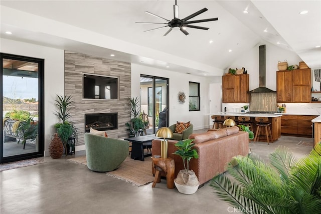 living area with finished concrete flooring, ceiling fan, a high end fireplace, and recessed lighting