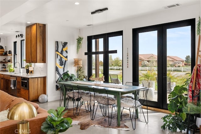 dining area featuring french doors, concrete flooring, recessed lighting, and visible vents