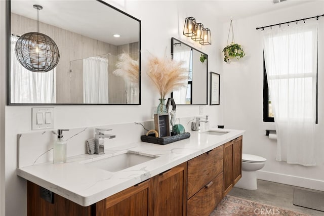 bathroom featuring a shower with curtain, double vanity, toilet, and a sink