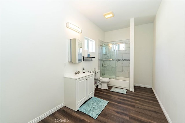 bathroom featuring baseboards, wood finished floors, toilet, and vanity
