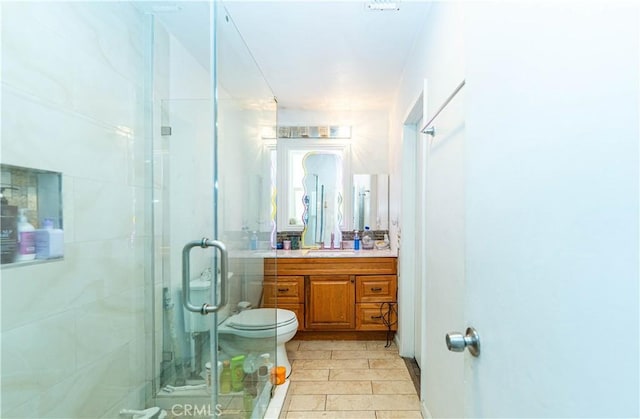 bathroom with toilet, a stall shower, and vanity