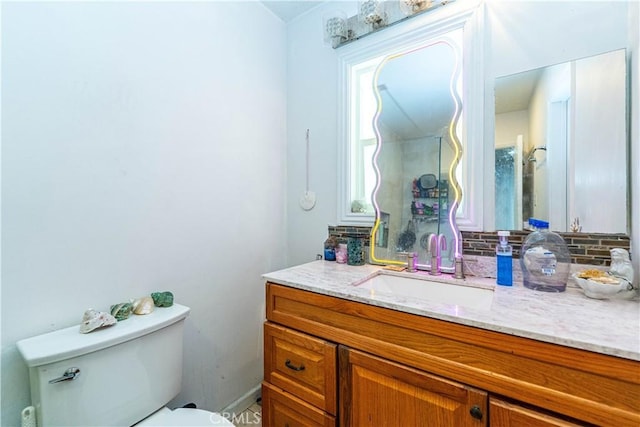 half bathroom featuring toilet, backsplash, and vanity