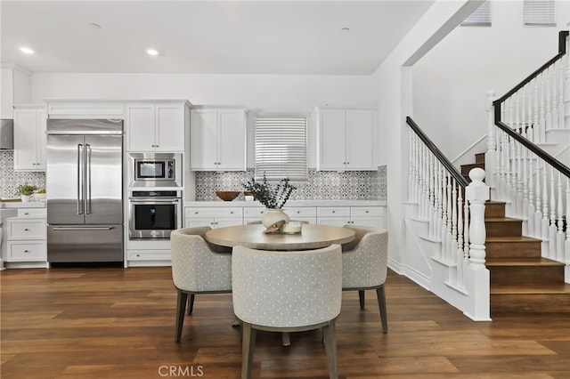 1711 Sonora Creek Ln, Lake Forest, CA 92610 - kitchen featuring white cabinets, dark wood-type flooring, built in appliances, and decorative backsplash