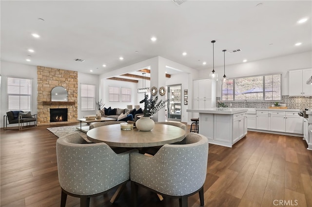 1711 Sonora Creek Ln, Lake Forest, CA 92610 - dining space featuring recessed lighting, visible vents, dark wood-style flooring, and a stone fireplace