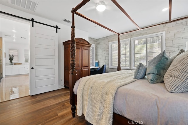 1711 Sonora Creek Ln, Lake Forest, CA 92610 - bedroom with wood finished floors, ensuite bathroom, visible vents, and a barn door
