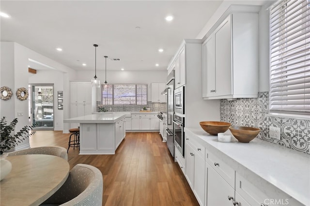 1711 Sonora Creek Ln, Lake Forest, CA 92610 - kitchen with a center island, light countertops, a kitchen breakfast bar, white cabinetry, and light wood-style flooring
