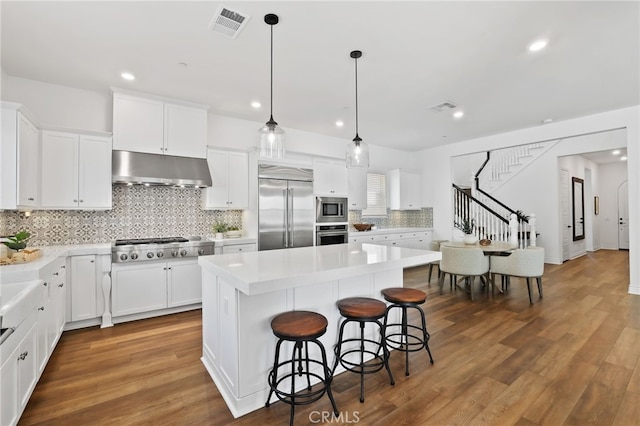 1711 Sonora Creek Ln, Lake Forest, CA 92610 - kitchen featuring visible vents, a breakfast bar, built in appliances, and under cabinet range hood