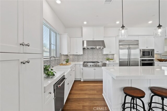 1711 Sonora Creek Ln, Lake Forest, CA 92610 - kitchen featuring visible vents, built in appliances, a sink, a kitchen bar, and under cabinet range hood