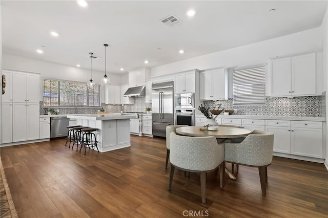 1711 Sonora Creek Ln, Lake Forest, CA 92610 - kitchen with visible vents, a breakfast bar, a center island, under cabinet range hood, and built in appliances