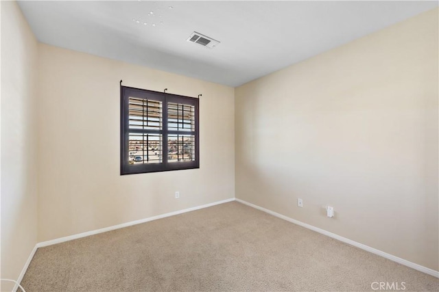 carpeted empty room with visible vents and baseboards