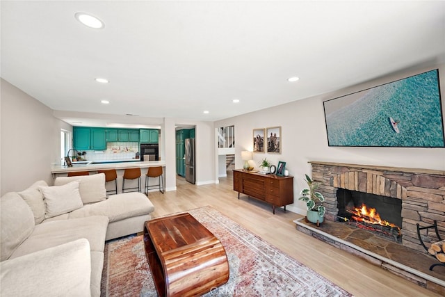 5649 Roane Dr, Oceanside, CA 92057 - living area featuring light wood-type flooring, a stone fireplace, recessed lighting, and baseboards