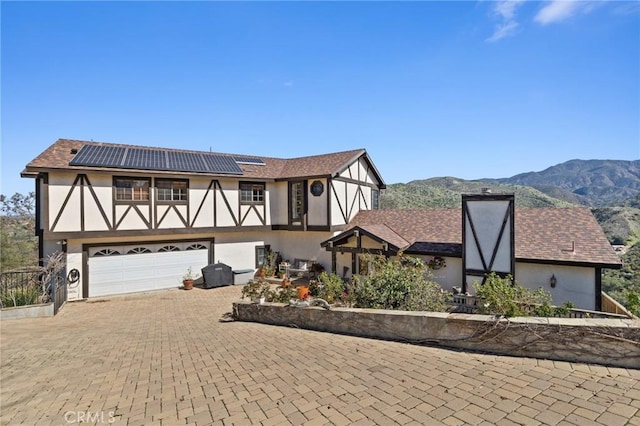 28061 Modjeska Grade, Modjeska Canyon, CA 92676 - tudor house featuring stucco siding, roof mounted solar panels, decorative driveway, a garage, and a mountain view