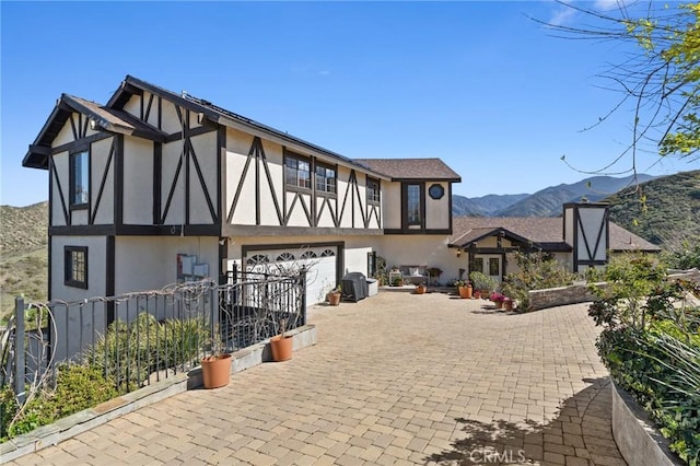 28061 Modjeska Grade, Modjeska Canyon, CA 92676 - view of front facade featuring stucco siding, a garage, a mountain view, and decorative driveway