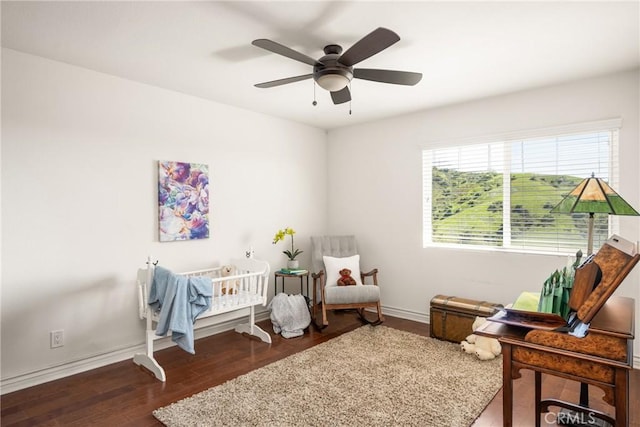 bedroom featuring wood finished floors, a ceiling fan, and baseboards
