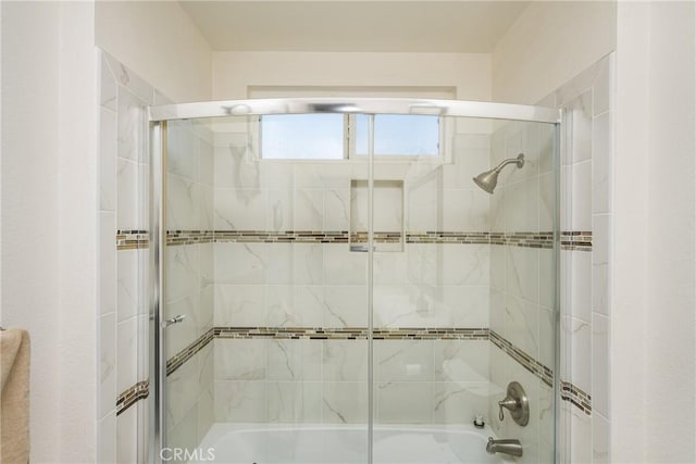 bathroom featuring combined bath / shower with glass door