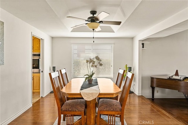 dining room featuring baseboards, a ceiling fan, and wood finished floors