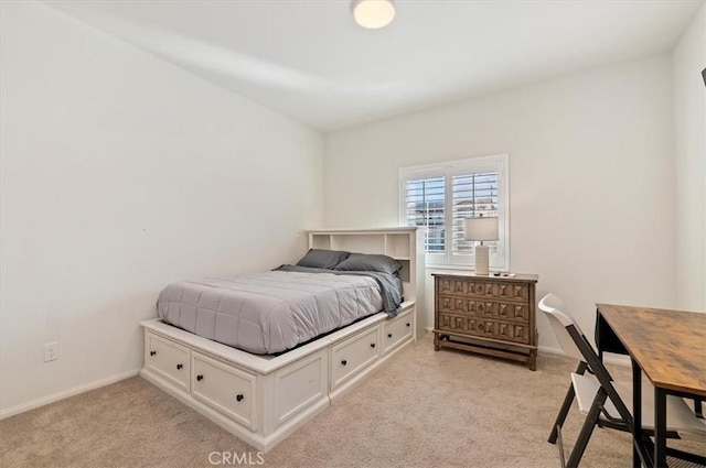 bedroom with light colored carpet and baseboards