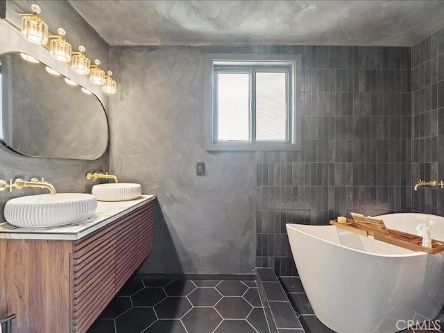 full bathroom featuring tile patterned floors, a soaking tub, tile walls, and vanity