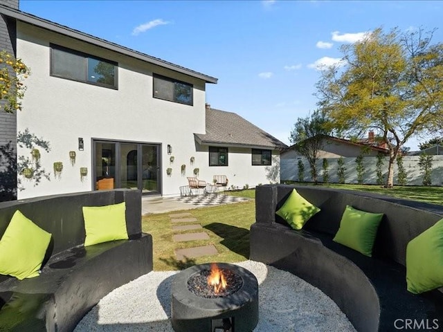 back of property featuring a patio, a fire pit, and stucco siding