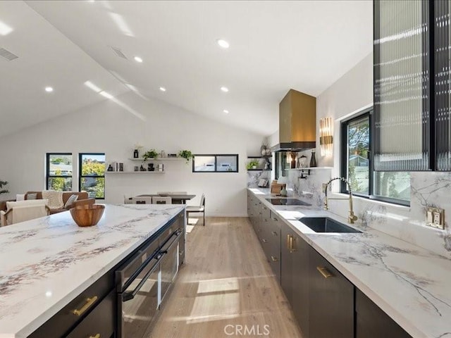 kitchen with light wood-style flooring, a sink, recessed lighting, black electric cooktop, and light stone countertops