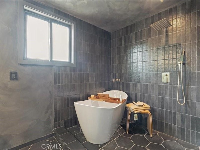 bathroom featuring tile patterned floors, a soaking tub, tiled shower, and tile walls