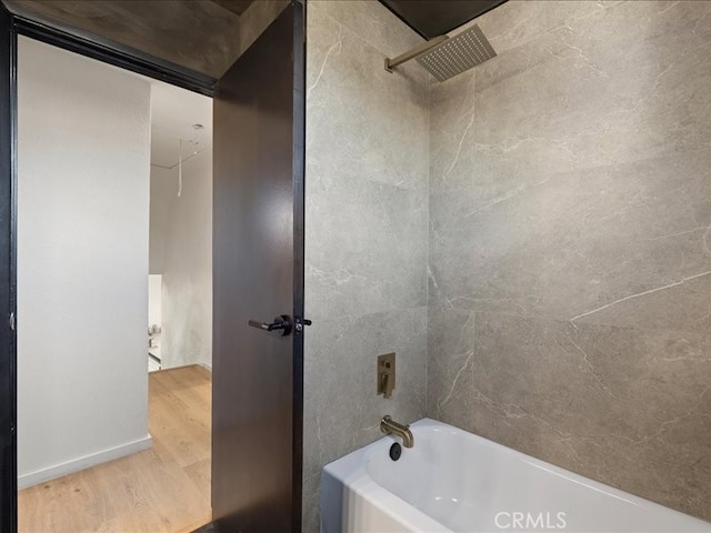 full bath featuring wood finished floors and tub / shower combination
