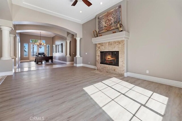 4195 Robby Cir, Corona, CA 92881 - unfurnished living room with ceiling fan, a tiled fireplace, wood finished floors, arched walkways, and decorative columns