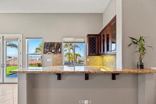 4195 Robby Cir, Corona, CA 92881 - kitchen featuring a breakfast bar area, glass insert cabinets, and healthy amount of natural light