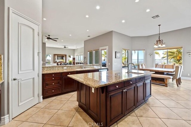 4195 Robby Cir, Corona, CA 92881 - kitchen with a sink, light tile patterned flooring, recessed lighting, a center island with sink, and light stone counters