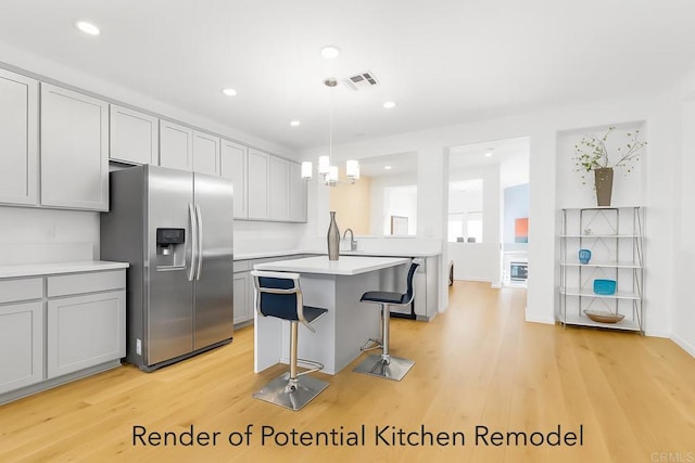 13325 Via Constanza Unit 2, San Diego, CA 92129 - kitchen featuring stainless steel refrigerator with ice dispenser, light countertops, light wood-style floors, a breakfast bar, and recessed lighting