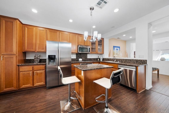 13325 Via Constanza Unit 2, San Diego, CA 92129 - kitchen featuring stainless steel appliances, brown cabinets, a kitchen island, recessed lighting, and glass insert cabinets