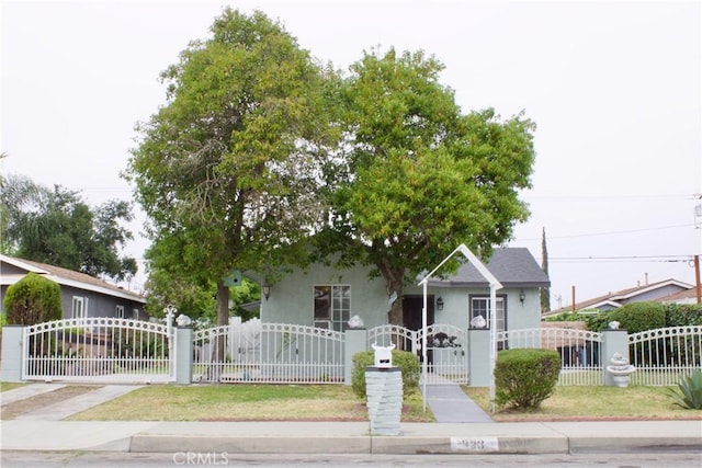 323 E Hanna St, Colton, CA 92324 - view of front of property with stucco siding, a fenced front yard, and a gate