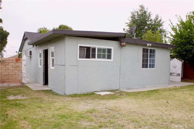 323 E Hanna St, Colton, CA 92324 - view of side of property featuring a yard, fence, and stucco siding