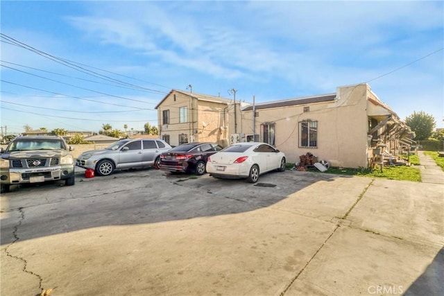 view of front of property with stucco siding and uncovered parking