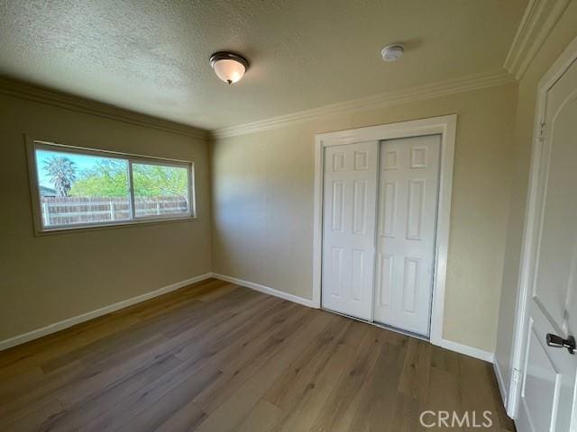 9286 San Benito Ave, Gerber, CA 96035 - unfurnished bedroom with wood finished floors, baseboards, ornamental molding, a closet, and a textured ceiling