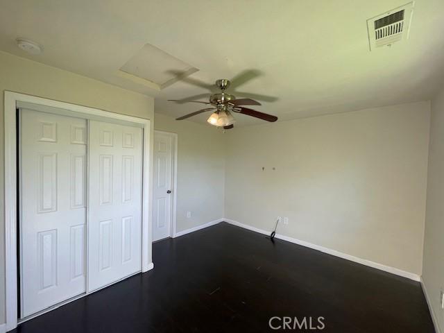 9286 San Benito Ave, Gerber, CA 96035 - unfurnished bedroom featuring a closet, baseboards, visible vents, and dark wood-style flooring