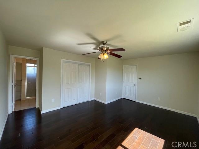 9286 San Benito Ave, Gerber, CA 96035 - unfurnished bedroom with visible vents, baseboards, dark wood-type flooring, and a ceiling fan