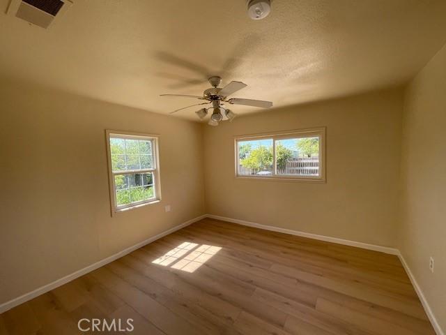 9286 San Benito Ave, Gerber, CA 96035 - empty room featuring a ceiling fan, wood finished floors, visible vents, and baseboards