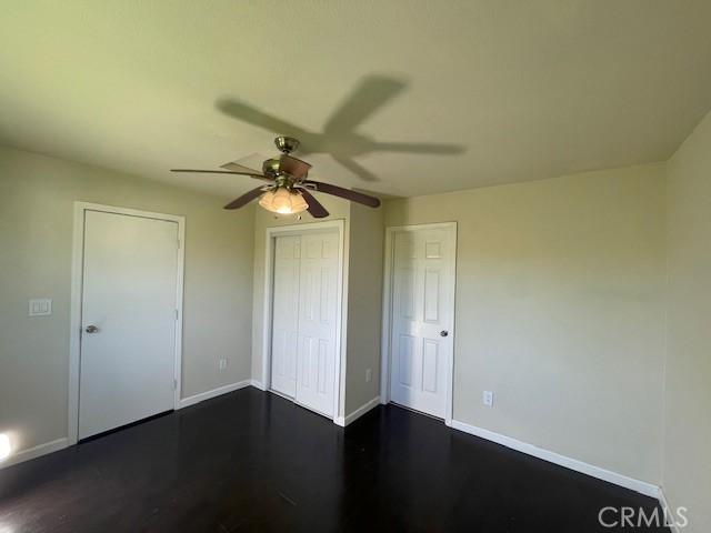 9286 San Benito Ave, Gerber, CA 96035 - unfurnished bedroom featuring ceiling fan, a closet, baseboards, and dark wood-style floors