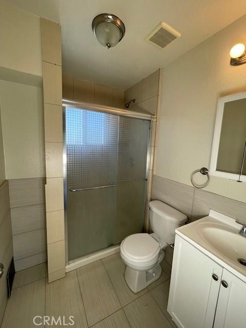 9286 San Benito Ave, Gerber, CA 96035 - full bath with a wainscoted wall, visible vents, a shower stall, tile walls, and toilet