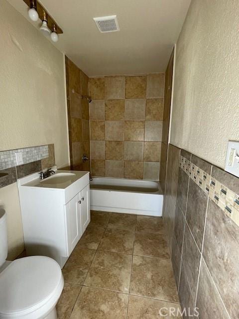 9286 San Benito Ave, Gerber, CA 96035 - full bathroom featuring tile patterned floors, visible vents, shower / bathtub combination, tile walls, and vanity