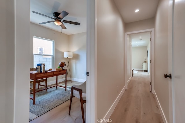 hall with light wood-style flooring, recessed lighting, and baseboards